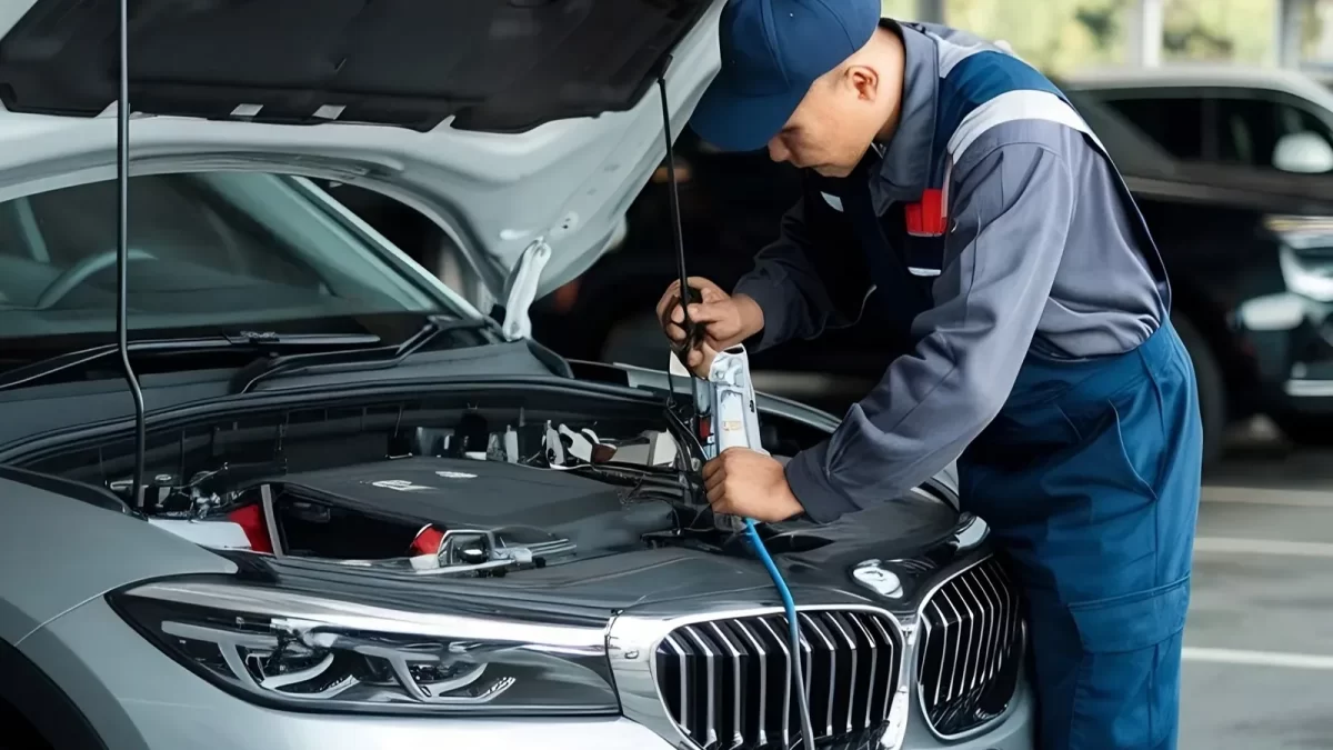 Technician checking a car air conditioner and refrigerant under the hood