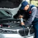 Technician checking a car air conditioner and refrigerant under the hood